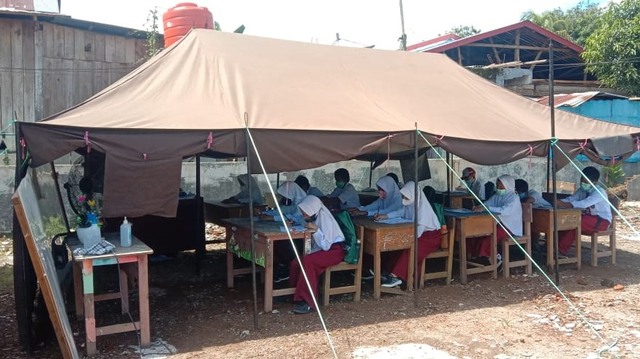 Siswa SD Inpres Simboro, Mamuju, Sulawesi Barat, mengawali hari pertama sekolah tatap muka dengan belajar di tenda darurat. Foto: Awal Dion/SulbarKini