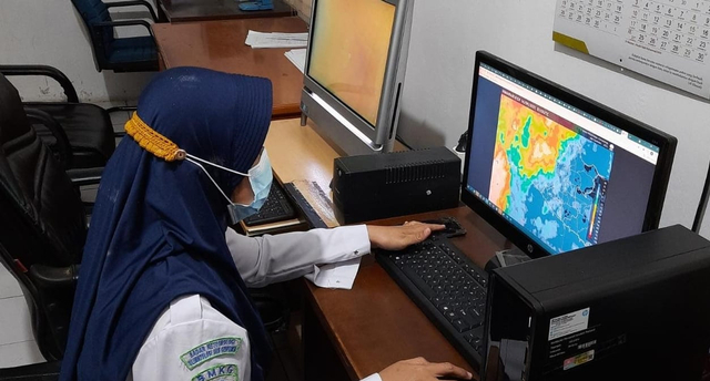 Prakirawan BMKG Stasiun Meteorologi Tegal, Sri Nurlatifah mengamati perkembangan cuaca melalui layar monitor di kantornya, Selasa (14/9/2021). (Foto: Setyadi)