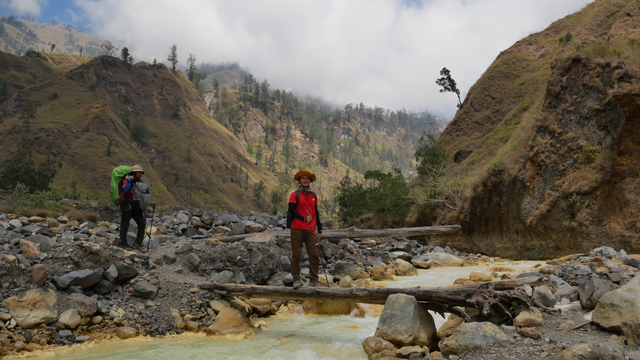 Dua orang pendaki saat menyeberangi salah satu anak sungai di lembah jalur pendakian Torean. Foto: Harley Sastha