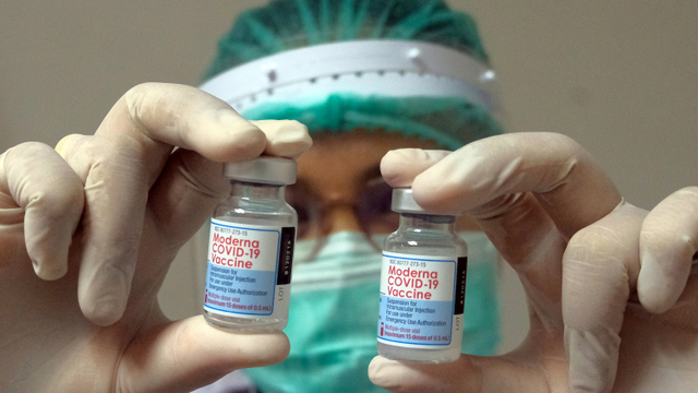 Petugas kesehatan menunjukkan vaksin Moderna saat vaksinasi COVID-19 dosis ketiga di Rumah Sakit Bali Mandara, Denpasar, Bali.  Foto: Nyoman Hendra Wibowo/ANTARA FOTO