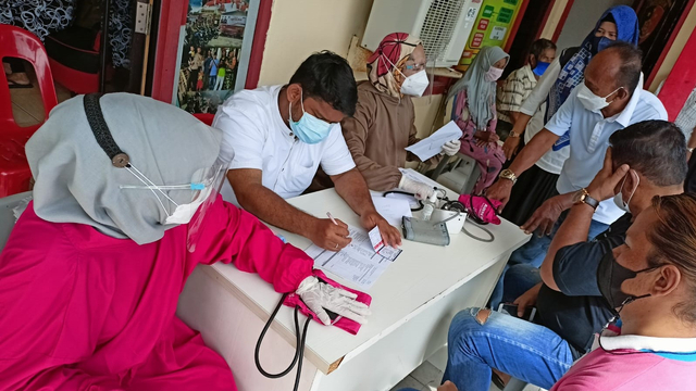 Petugas vaksinasi saat memeriksa warga yang akan divaksinasi COVID-19. Foto: Zalfirega/kepripedia.com.