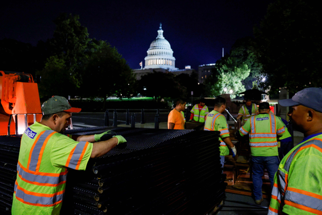 Pekerja memasang pagar keamanan di sekitar US Capitol, di Washington, Amerika Serikat, Rabu (15/9). Foto: Jonathan Ernst/Reuters