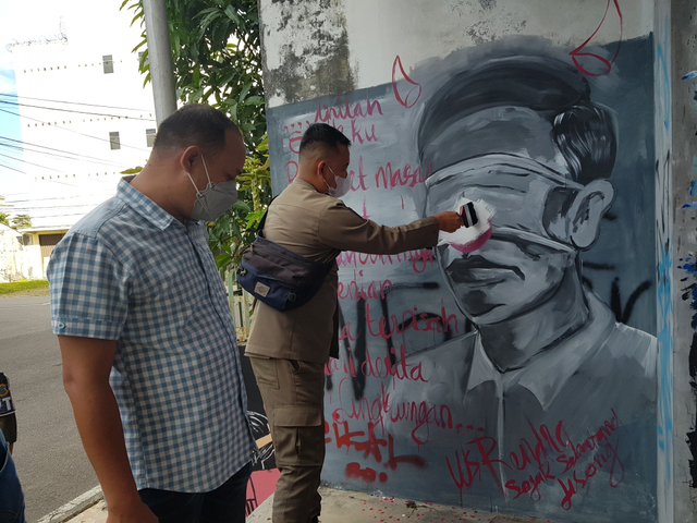 Petugas Satpol PP Kota Pangkalpinang saat hapus mural mirip wajah Jokowi.