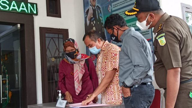 Dr Saiful Mahdi didampingi kuasa hukumnya menandatangani berita acara eksekusi di Kejari Banda Aceh sebelum dibawa ke Lapas Kelas IIA Lambaro. Foto: Husaini/acehkini