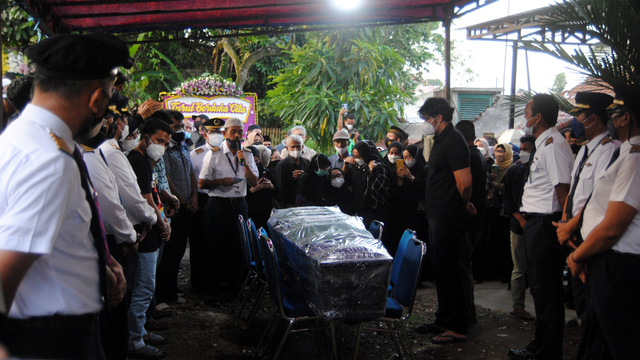 Sejumlah anggota keluarga dan kerabat menyambut kedatangan peti jenazah pilot Rimbun Air Kapten Agithia Mirza saat di rumah duka Komplek AURI, Kelurahan Curug, Kota Bogor, Jawa Barat, Jumat (17/9/2021). Foto: Arif Firmansyah/ANTARA FOTO