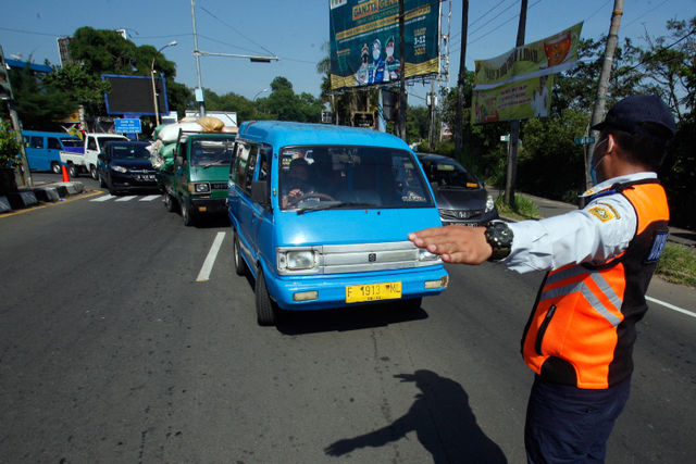 Petugas gabungan Satgas COVID-19 Kabupaten Bogor mengarahkan kendaraan saat penerapan sistem ganjil genap di Jalan Raya Puncak, Gadog, Ciawi, Kabupaten Bogor, Jawa Barat, Sabtu (18/9/2021). Foto: YULIUS SATRIA WIJAYA/ANTARA FOTO