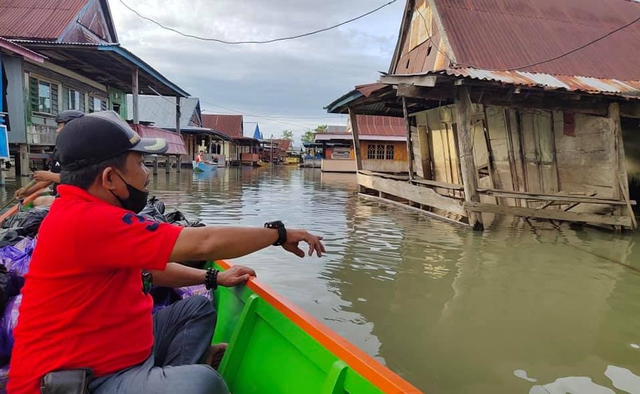Anggota DPRD Kabupaten Wajo, Sudirman Meru, saat membagikan sembako ke warga terdampak banjir. Foto: Dok. Istimewa