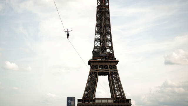 Akrobatik Prancis Nathan Paulin berjalan di tali antara Menara Eiffel dan Teater National de Chaillot di Paris, Prancis, Sabtu (18/9). Foto: Benoit Tessier/REUTERS