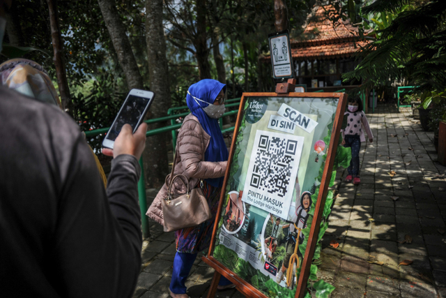 Pengunjung memindai kode batang dari aplikasi peduli lindungi sebelum memasuki kawasan wisata The Lodge Maribaya, Lembang, Kabupaten Bandung Barat, Jawa Barat, Jumat (17/9).  Foto: Raisan Al Farisi/ANTARA FOTO