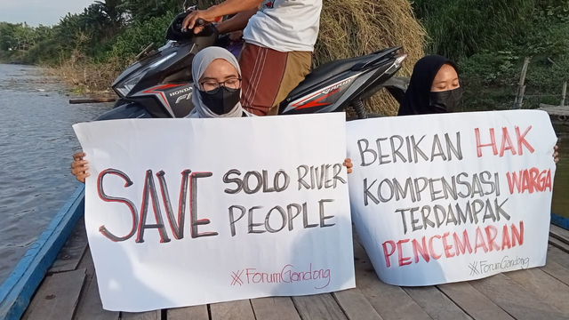 Forum Gandong, asal Kecamatan Gayam, Kabupaten Bojonegoro, saat menggelar aksi protes, dengan membentangkan poster bernada tuntututan akibat terjadinya pencemaran di Sungai Bengawan Solo. (istimewa)