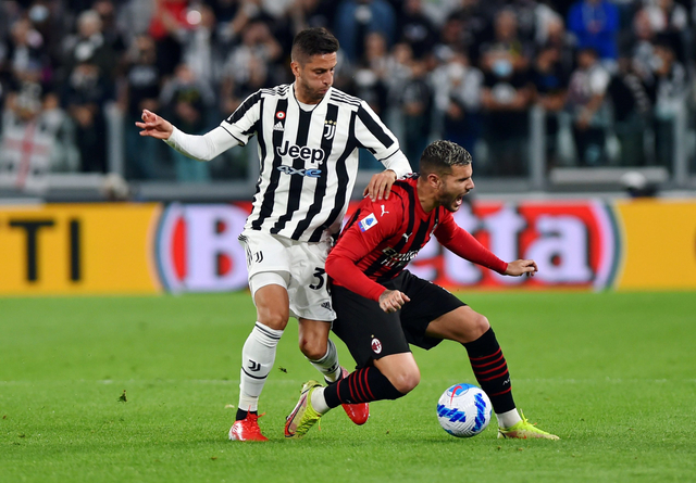 Pemain AC Milan Theo Hernandez duel dengan pemain Juventus Rodrigo Bentancur saat pertandingan di Allianz Stadium, Turin, Italia. Foto: Massimo Pinca/Reuters