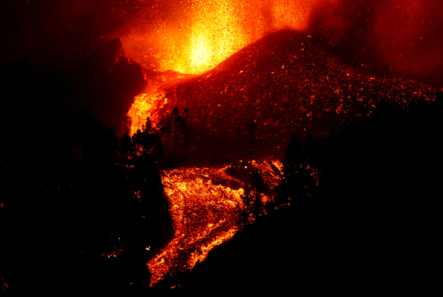 Lava mengalir menuruni bukit setelah letusan gunung berapi di taman nasional Cumbre Vieja di El Paso, di Pulau Canary La Palma, Spanyol, Minggu (19/9/2021). Foto: Borja Suarez/REUTERS