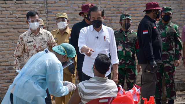 Presiden Joko Widodo meninjau vaksinasi dari pintu ke pintu (door to door) di Desa Emplasemen, Kecamatan Beringin, Kabupaten Deliserdang, Sumatera Utara. Foto: Fransisco Carolio/ANTARA FOTO