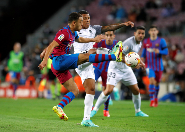 Pemain FC Barcelona Sergino Dest duel dengan pemain Granada Darwin Machis di Camp Nou, Barcelona, Spanyol. Foto: Albert Gea/Reuters