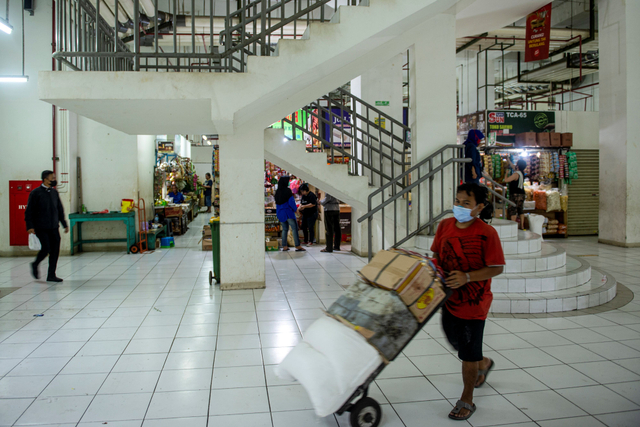 Pekerja mengangkut barang dagangan di Rumah Susun Pasar Rumput, Manggarai, Jakarta, Senin (20/9/2021). Foto: M Risyal Hidayat/Antara Foto