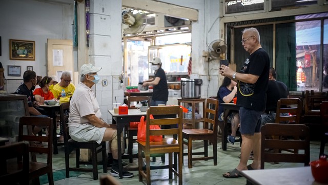 Dua orang warga keturunan Tionghoa mengambil foto pada salah satu kedai kopi legendaris di kawasan Pecinan Glodok, Taman Sari, Jakarta Barat, Sabtu (18/9). Foto: Iqbal Firdaus/kumparan