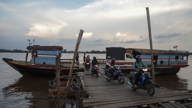 Warga memanfaatkan jasa transportasi kapal kayu tradisional untuk menyeberangi Sungai Kahayan menuju Desa Maliku, Kabupaten Pulang Pisau, Kalimantan Tengah, Senin (20/9/2021). Foto: Makna Zaezar/ANTARA FOTO