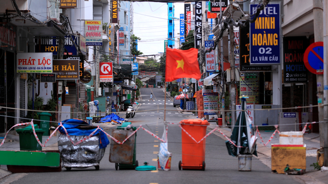 Sebuah gang diblokir dengan tempat sampah dan bendera Vietnam di Vung Tau, Vietnam, Senin (20/9). Foto: Hau Dinh/AP Photo