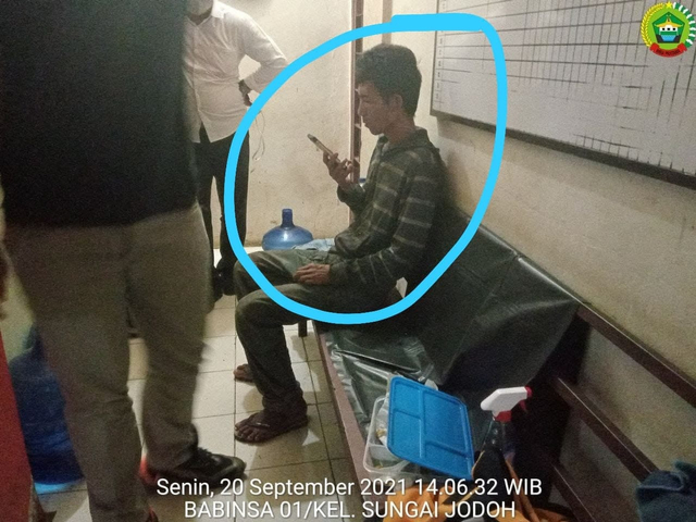 Pelaku penyerang Ustaz Chaniago sedang serius menatap layar ponsel. (Foto: ist/Batamnews)