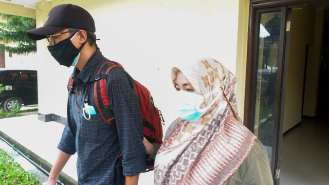 Bupati Kolaka Timur, Andi Merya Nur (menggunakan jilbab) keluar dari ruang pemeriksaan Ditreskrimsus Polda Sultra. Foto: Deden Saputra/kendarinesia.