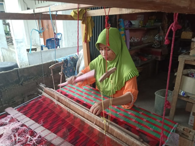 Seorang pengrajin sedang menenun di Kampung Wisata Tenun Khatulistiwa, Pontianak. Foto: Dok. Hi!Pontianak