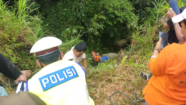 Polisi dan petugas BPBD saat mengevakuasi bus masuk jurang di Kabupaten Dairi. Foto: Dok. Istimewa