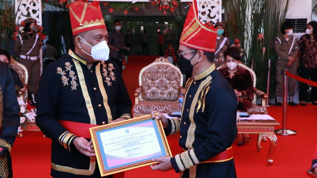 Gubernur Sulawesi Utara, Olly Dondokambey, saat menyerahkan piagam penghargaan ke Bupati Minut, Joune Ganda