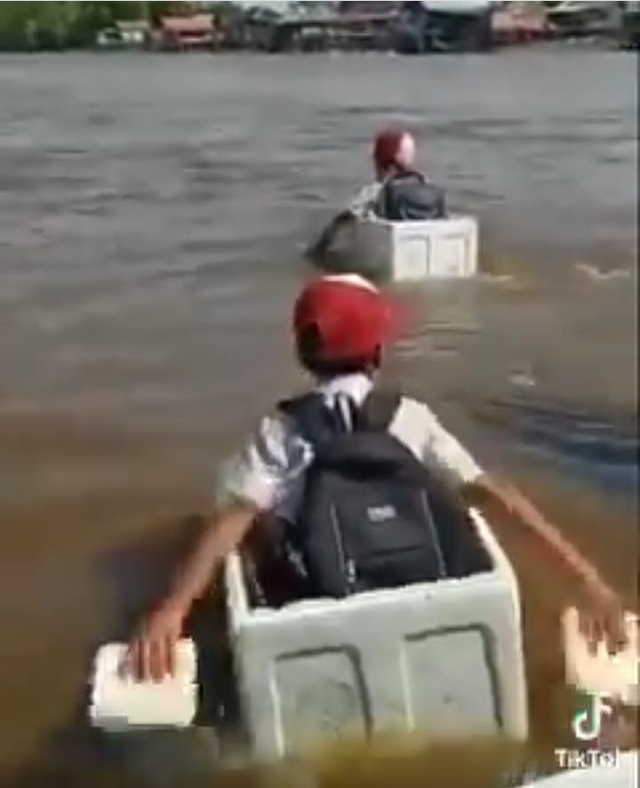 Anak-anak SD menyeberang sungai menggunakan kotak styrofoam. Foto: Tangkapan Layar Instagram @pontianakviral