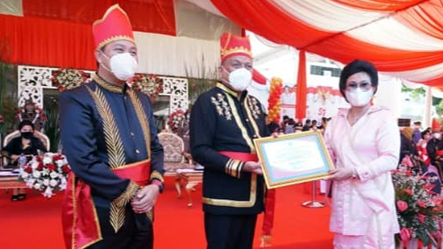 Bupati Sitaro, Evangelian Sasingen, saat menerima penghargaan yang diserahkan Gubernur Sulawesi Utara, Olly Dondokambey. (foto: dokumen istimewa)
