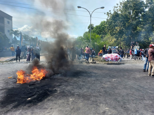 Massa aksi membakar ban saat menggelar aksi demonstrasi di depan Mapolda Sultra. Foto: Deden Saputra/kendarinesia.