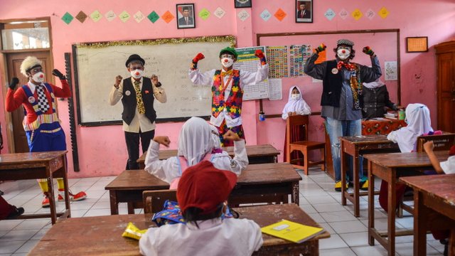 Empat anggota Komunitas Badut Tasikmalaya (Battik) menyanyikan lagu 3M saat sosialisasi protokol kesehatan pada pembelajaran tatap muka SD Negeri Dadaha, Kota Tasikmalaya, Jawa Barat, Senin (27/9/2021). Foto: Adeng Bustomi/ANTARA FOTO