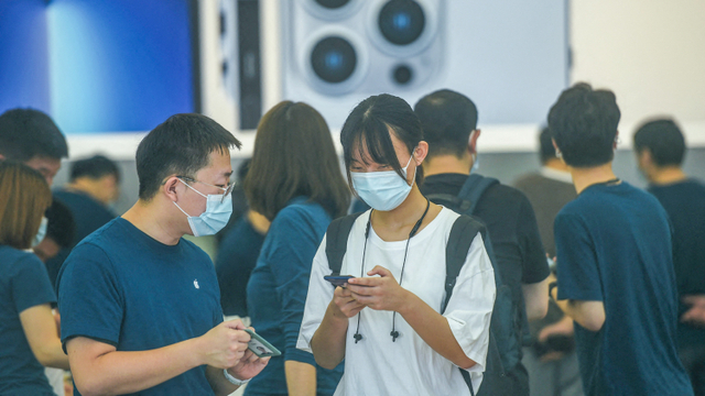 Pelanggan mencoba ponsel iPhone 13 yang baru diluncurkan di toko Apple di Hangzhou, di provinsi Zhejiang timur China pada 24 September 2021. Foto: STR / AFP / China OUT