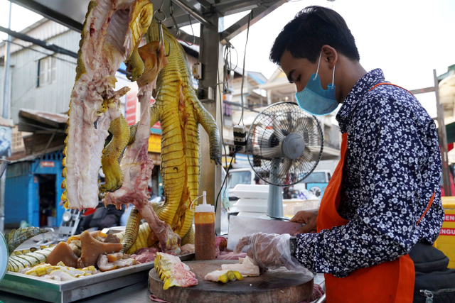 Pedagang menyiapkan olahan daging buaya di Phnom Penh, Kamboja, Senin (27/9/2021). Foto: Cindy Liu/Reuters