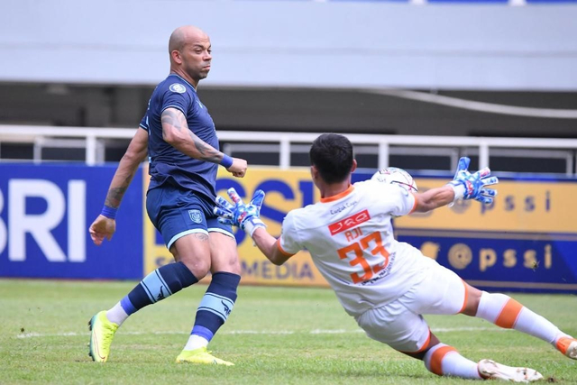 Kiper Persiraja Banda Aceh Aji Bayu Putra saat menghalau bola dari striker Persela Lamongan, Ivan Carlos, dalam laga pekan kelima Liga 1 2021/22 di Stadion Pakansari, Selasa (28/9). Foto: Twitter @PerselaFC 