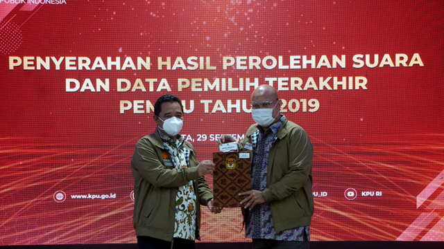 Direktur Jenderal Politik dan Pemerintahan Umum Kemendagri, Bahtiar, dan Ketua KPU RI, Ilham Saputra (kanan), pada Penyerahan Hasil Pemilu tahun 2019 di Gedung KPU RI, Jakarta, Rabu (29/9/2021). Foto: Jamal Ramadhan/kumparan