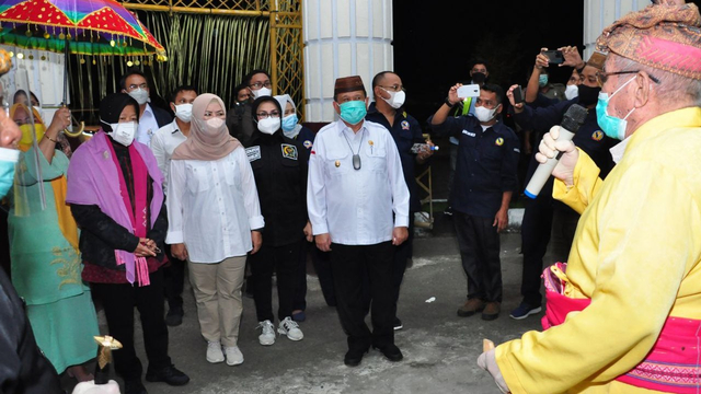 Menteri Sosial RI Tri Rismaharini (kiri) saat menerima prosesi adat mopotilolo di Bandara Djalaludin Gorontalo. Kamis, (30/9/2021). Foto: Dok istimewa