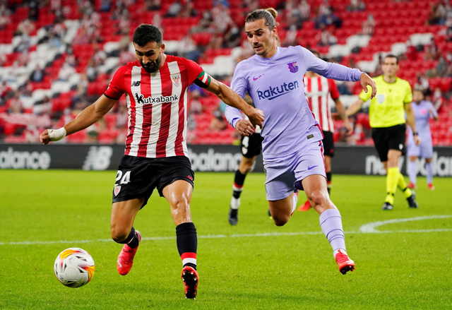 Mikel Balenziaga dari Athletic Bilbao beraksi dengan Antoine Griezmann dari FC Barcelona saat pertandingan LaLiga di San Mames, Bilbao, Spanyol. Foto: Vincent West/Reuters