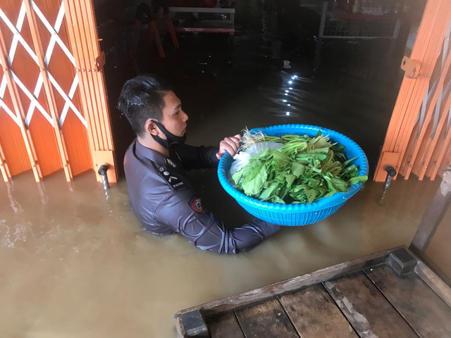 Personel Polsek Serawai membantu warga mengevakuasi bahan makanan. Foto: Dok Polres Sintang