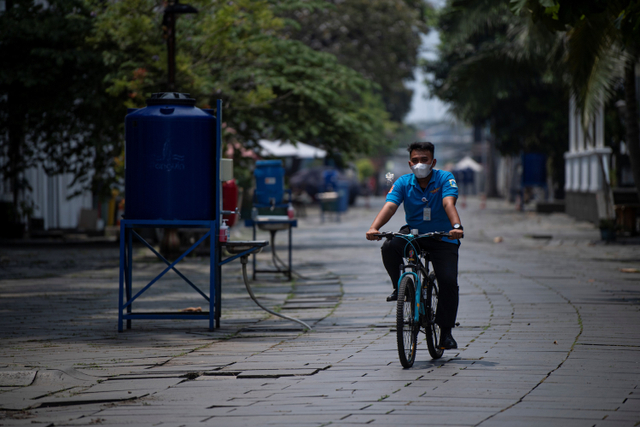 Petugas keamanan berpatroli dengan sepeda di kawasan wisata Kota Tua yang masih ditutup di Jakarta, Minggu (3/10).  Foto: Sigid Kurniawan/ANTARA FOTO