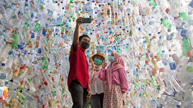 Warga berfoto selfie di terowongan "Terowongan 4444" yang dibangun dari 4444 botol plastik yang dikumpulkan dari beberapa sungai di sekitar kota dalam tiga tahun, di museum plastik. Foto: Prasto Wardoyo/Reuters