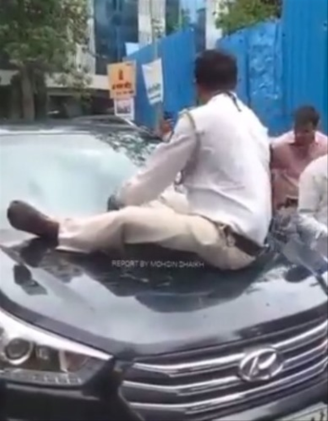 Aksi heroik seorang polantas bernama Vijay Singh Gurav naik ke kap mobil demi menghentikan pelanggar lalu lintas. (Foto: Twitter/@mohsinofficail)