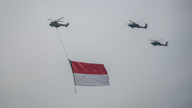 Tiga helikopter TNI terbang dengan mengibarkan bendera merah putih di kawasan Monas, Jakarta, Selasa (5/10/2021). Foto: Aprillio Akbar/ANTARA FOTO