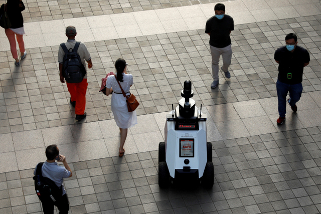 Robot otonom Xavier berpatroli di mal lingkungan untuk mendeteksi perilaku sosial warga dalam langkah-langkah keamanan COVID-19 di Singapura. Foto: Edgar Su/REUTERS