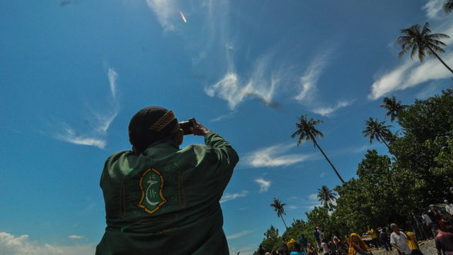 Ribuan warga Palu mengabadikan fenomena alam awan berlafaz Allah saat tradisi Mandi Safar di Palu, Sulawesi Tengah, Rabu (6/10). Foto: Tim Palu Poso 