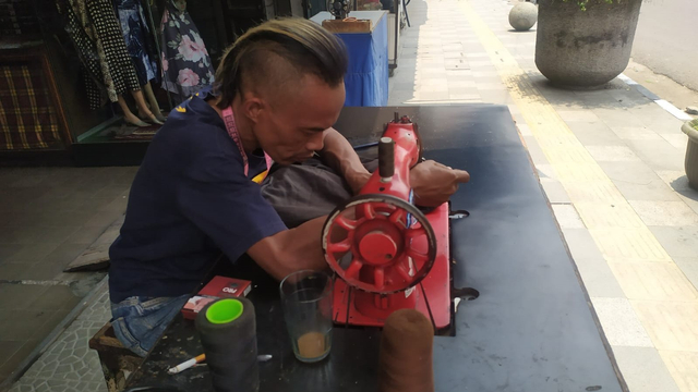 Ade Londok, yang dulu viral promosi Odading Mang Oleh kini kembali sebagai tukang jahit di Jalan Kosambi, Kota Bandung. Foto: Rachmadi Rasyad/kumparan