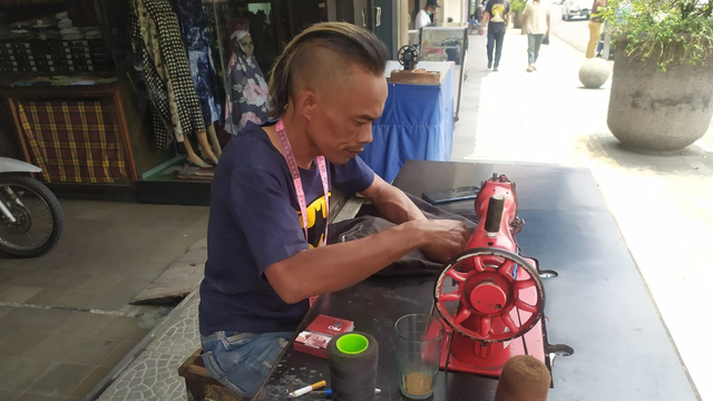 Ade Londok, yang dulu viral promosi Odading Mang Oleh kini kembali sebagai tukang jahit di Jalan Kosambi, Kota Bandung. Foto: Rachmadi Rasyad/kumparan
