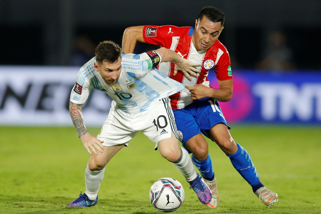 Pemain Argentina Lionel Messi beraksi dengan pemain Paraguay Angel Cardozo pada Kualifikasi Piala Dunia 2022 di Defensores del Chaco, Asuncion, Paraguay, Kamis (7/10). Foto: Cesar Olmedo/REUTERS