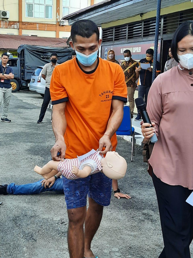 Adegen RA mengangkat jenazah anak 5 tahun yang dibunuhnya bersamaan dengan kakek korban yakni Sugiyono. Foto: Yusrizal/Hi! Pontianak