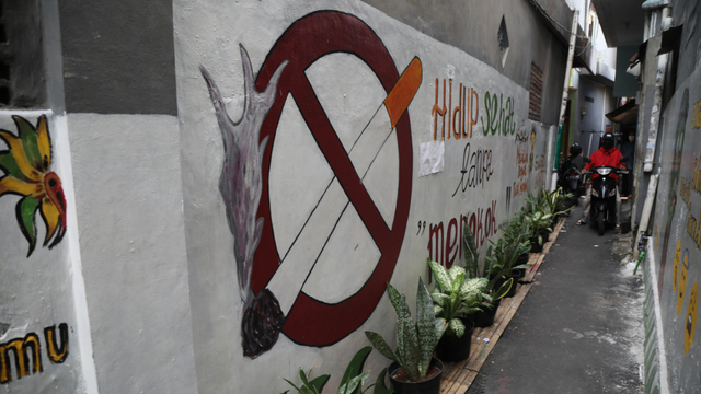 Warga melintasi mural di area kawasan tanpa asap rokok di kawasan kelurahan Kayu Manis, Matraman, Jakarta, Sabtu (9/10). Foto: Aditia Noviansyah/kumparan