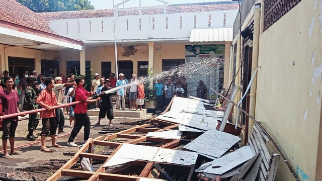 Warga berusaha memadamkan api yang membakar atap bangunan di komplek Balai Desa Dukuhtengah Kecamatan Ketanggungan Kabupaten Brebes, Minggu (10/10/2021).